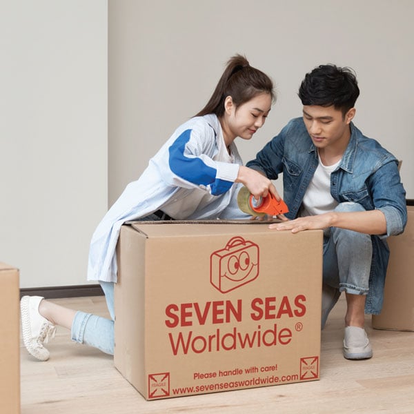 Couple sealing a shipping box