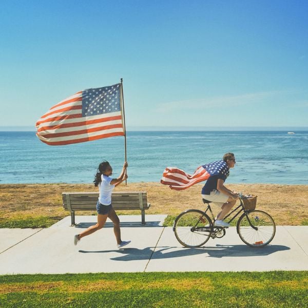 Happy people flying an American flag on the seafront