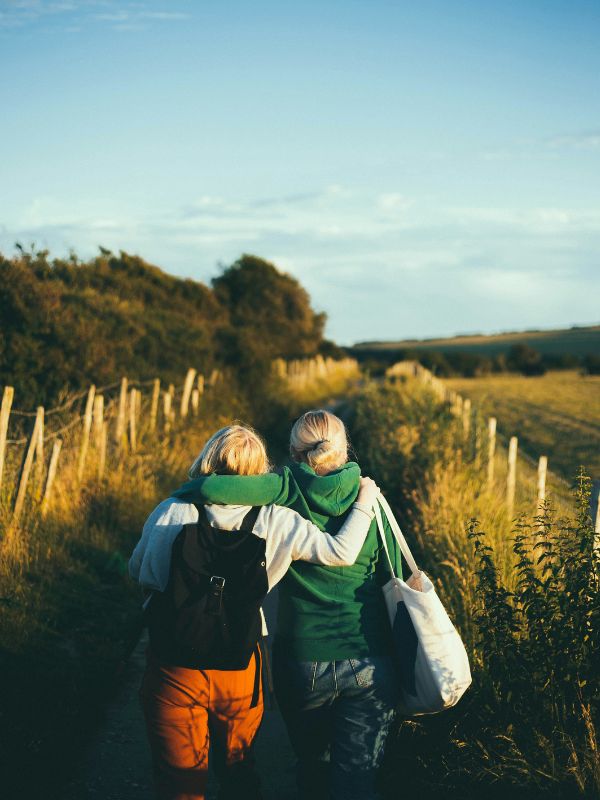 Two women walking through a field in Sussex, UK