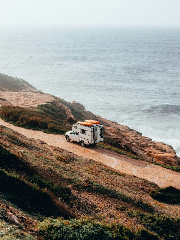 Caravan driving along a road by the ocean