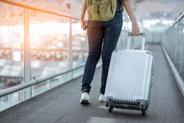 Woman with a suitcase walking through an airport