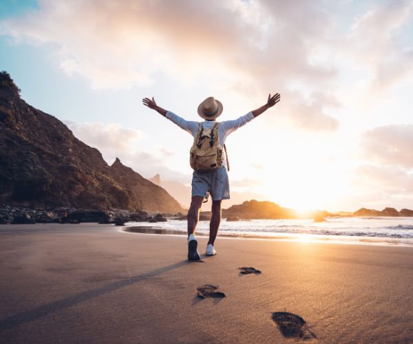 Cheering person on a beach at sunset