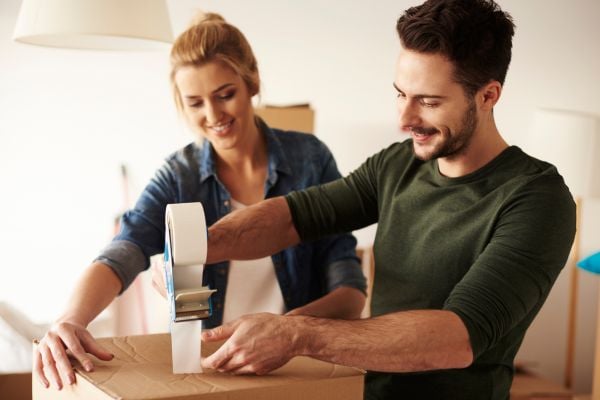 Couple taping a box closed