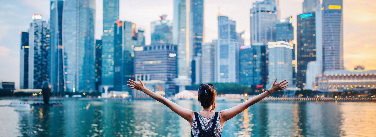 Woman with outspread arms overlooking the Singapore skyline