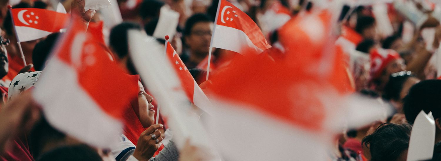 People waving Singapore flags