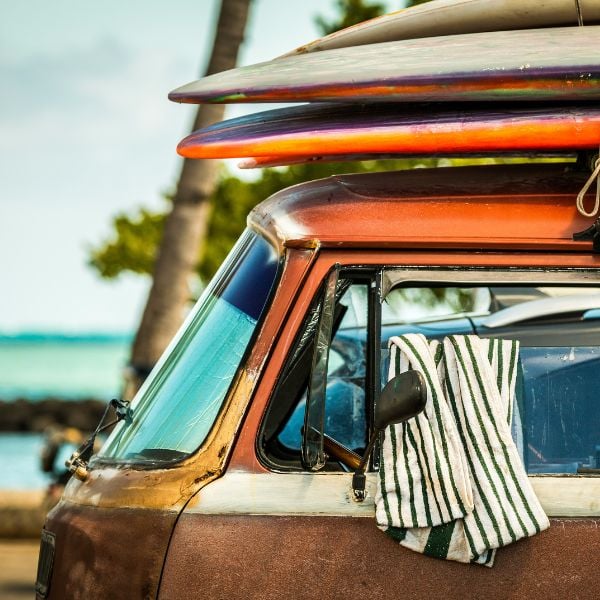 Old van in Hawaii with surfboards stacked on top