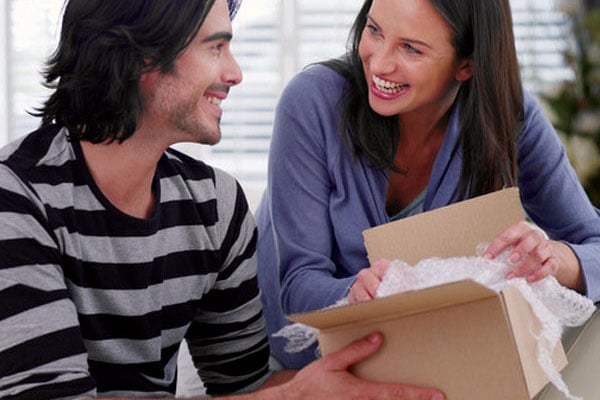 Couple unwrapping goods after shipping overseas