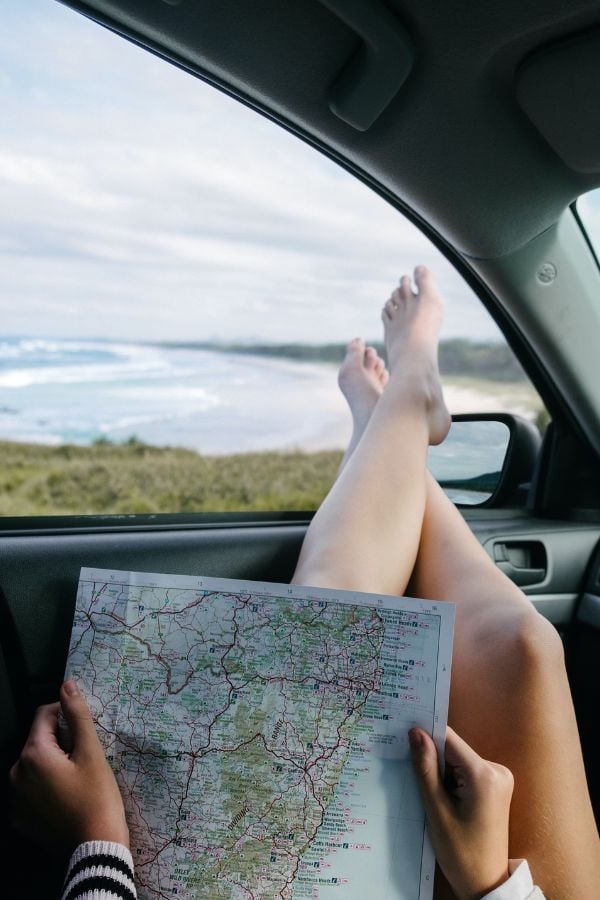 Woman Sitting In A Car Holding A Map