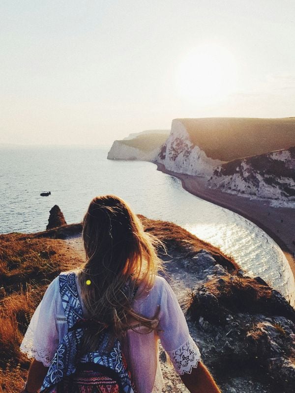 Young woman hiking on the cliffs beside the sea