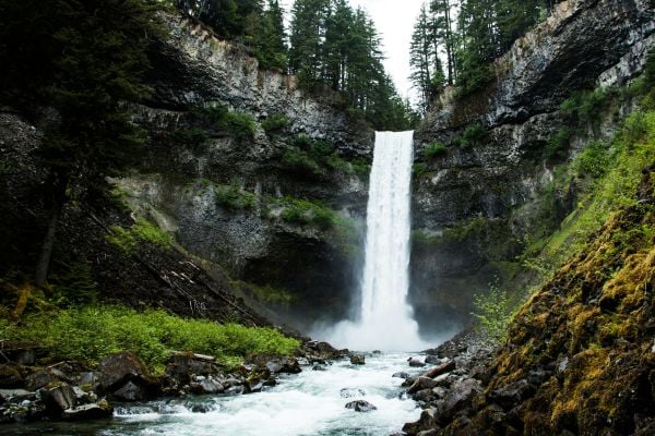 Waterfall over granite rocks surrounded by fir trees in Canada