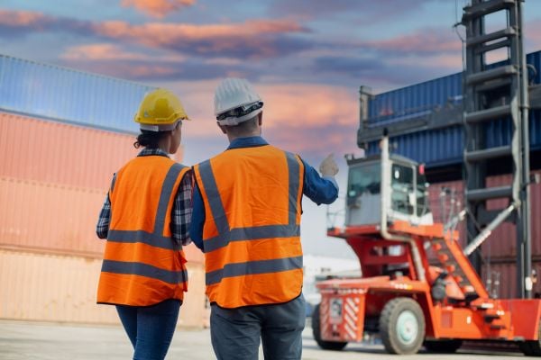 Two port workers overseeing the movement of cargo