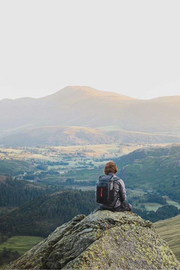 Man sitting on a rock overlooking the UK countryside