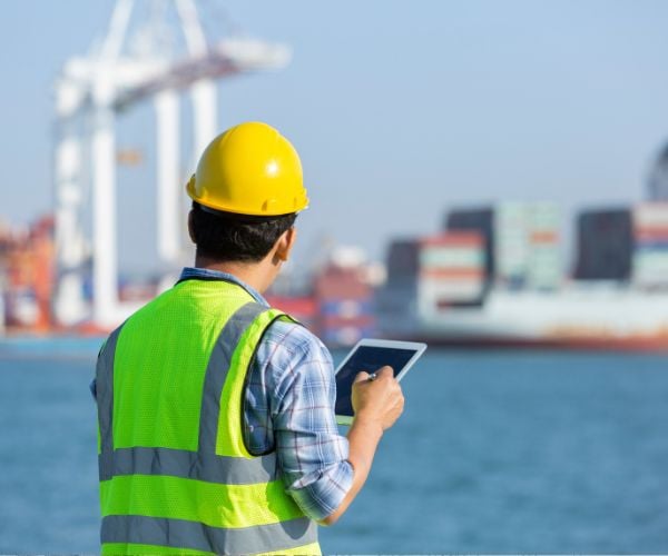 Man overseeing the movement of containers at aa port