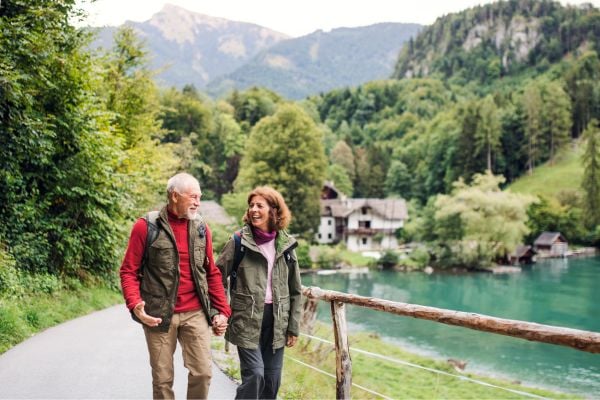 Older couple hiking near a river in the mountains